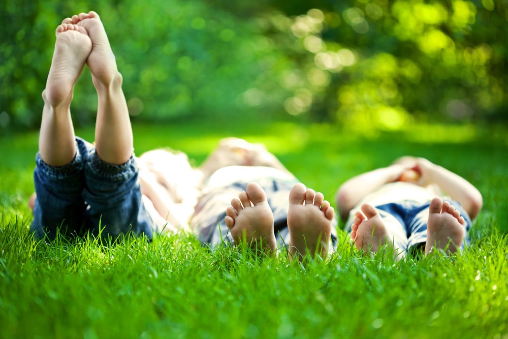 A Happy Children Lying On Green Grass